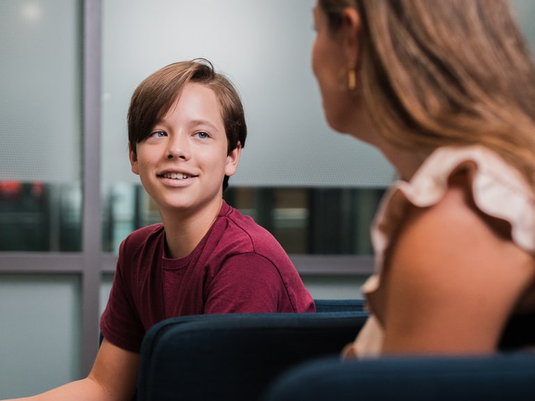 Ung gutt som smiler og ser på en voksen